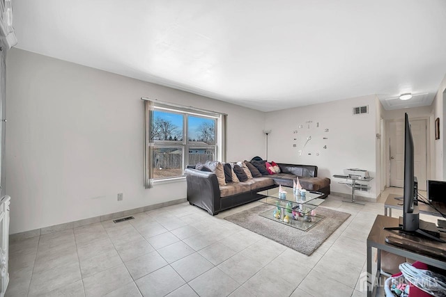 living room featuring light tile patterned flooring, visible vents, and baseboards