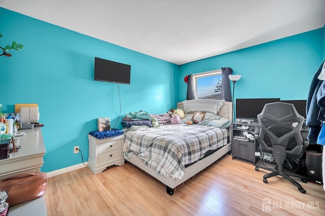 bedroom with baseboards and light wood finished floors