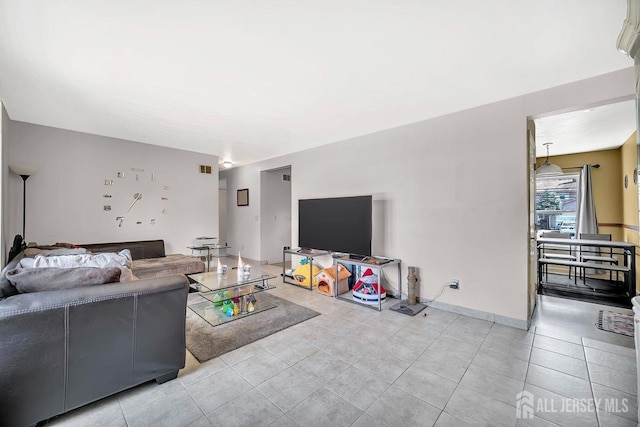 living area with baseboards and light tile patterned flooring