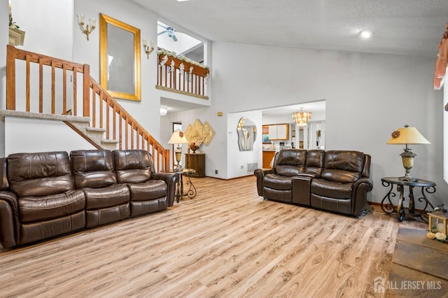 236 Community Cir, Old Bridge, NJ 08857 - living room with wood finished floors, a chandelier, stairs, ceiling fan, and high vaulted ceiling