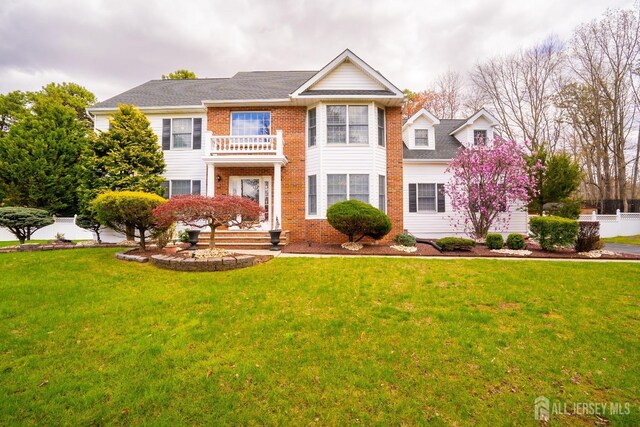 3 Clark Ct, Monroe, NJ 08831 - georgian-style home featuring brick siding, a front yard, a balcony, and fence