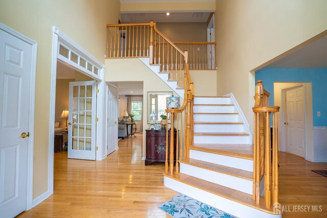 3 Clark Ct, Monroe, NJ 08831 - staircase with wood finished floors, a high ceiling, baseboards, and french doors