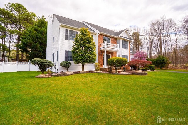 3 Clark Ct, Monroe, NJ 08831 - view of front of home featuring a front lawn, a chimney, fence, brick siding, and a balcony