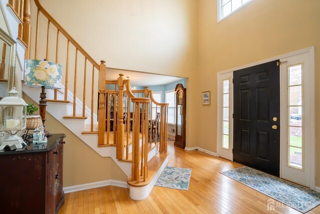 3 Clark Ct, Monroe, NJ 08831 - entrance foyer with hardwood / wood-style flooring, a healthy amount of sunlight, a towering ceiling, and stairway
