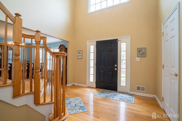 3 Clark Ct, Monroe, NJ 08831 - entrance foyer featuring a towering ceiling, visible vents, light wood-type flooring, baseboards, and stairs