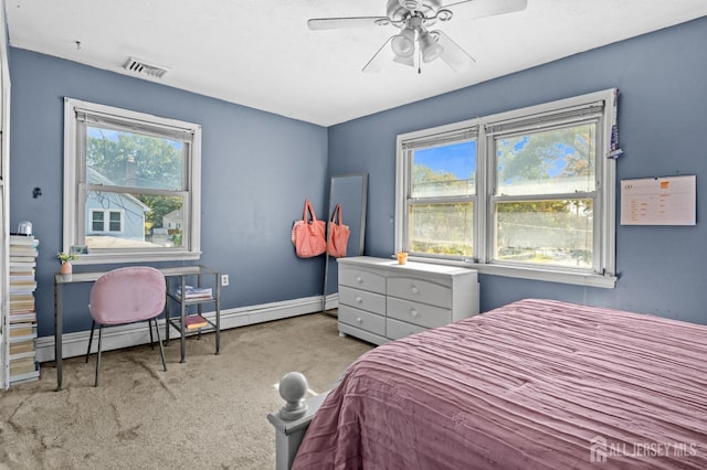 carpeted bedroom featuring ceiling fan, a baseboard radiator, visible vents, and baseboards