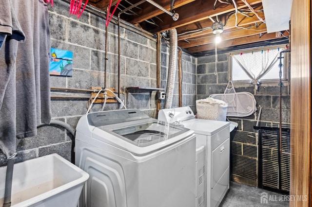 laundry area with laundry area, a sink, and separate washer and dryer