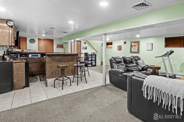 living room with light carpet, a bar, light tile patterned flooring, and visible vents