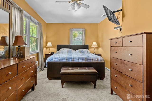 bedroom with ceiling fan, baseboards, and light colored carpet