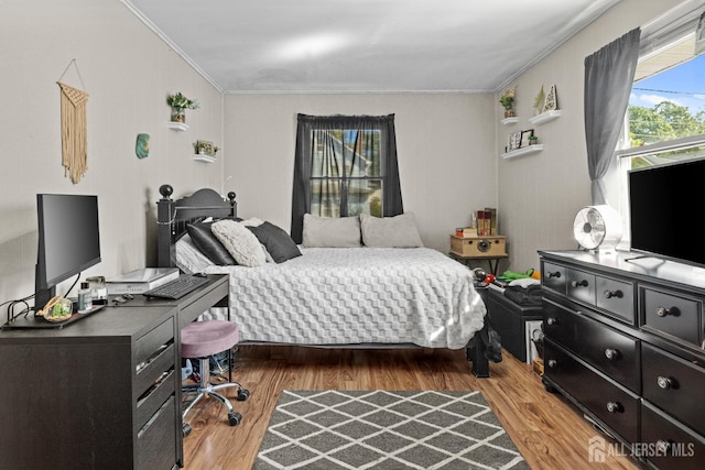 bedroom featuring ornamental molding and wood finished floors