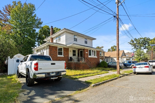 american foursquare style home with brick siding and a chimney