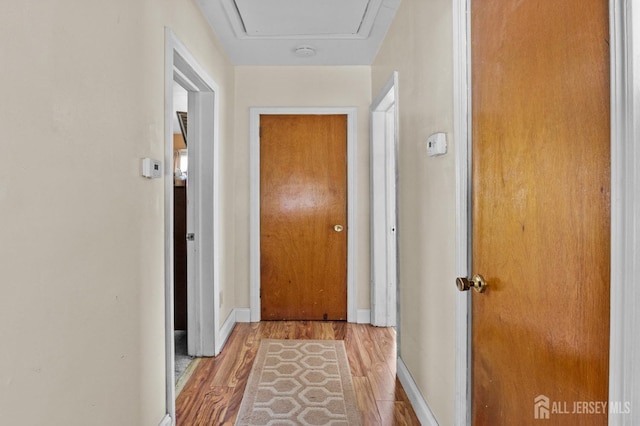 hallway with wood finished floors and baseboards