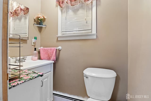 bathroom with toilet, a baseboard heating unit, and vanity