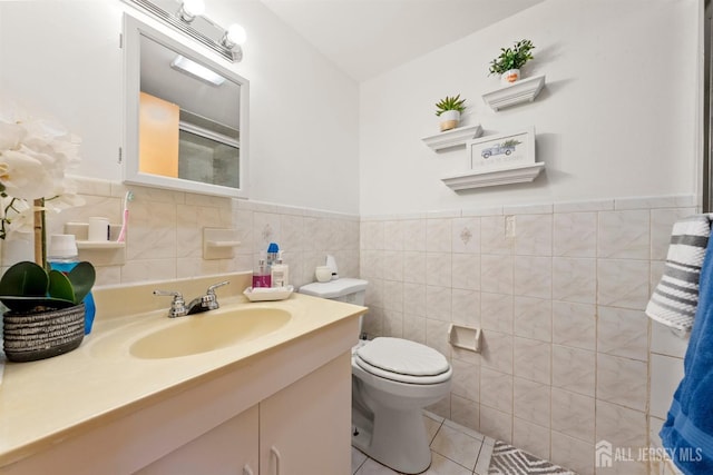 47 Florida St, Elizabeth, NJ 07206 - bathroom featuring tile walls, toilet, vanity, tile patterned flooring, and wainscoting