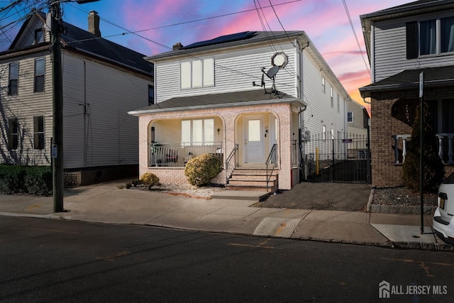 47 Florida St, Elizabeth, NJ 07206 - view of front facade featuring brick siding, a porch, and fence