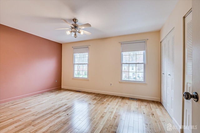 unfurnished bedroom with visible vents, a ceiling fan, light wood finished floors, and baseboards
