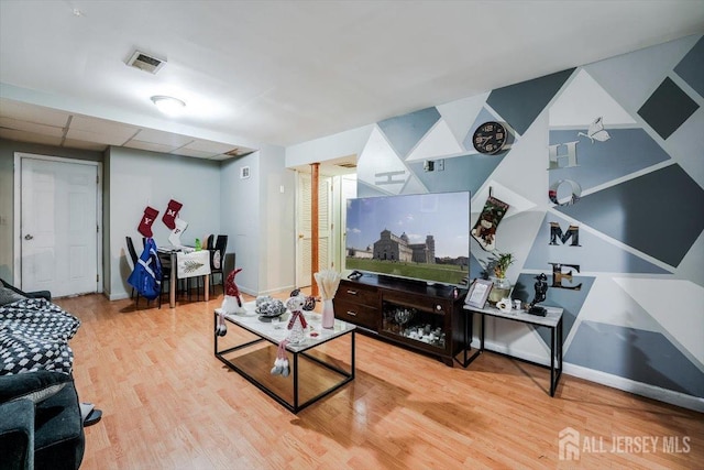 living room with hardwood / wood-style flooring and a drop ceiling