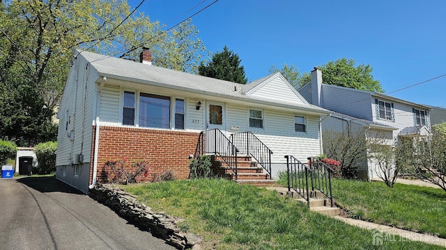 view of front of house featuring a chimney and brick siding