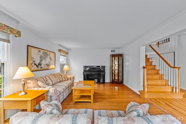 living room with crown molding, a healthy amount of sunlight, and wood-type flooring