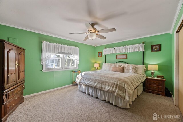 bedroom featuring light colored carpet, ornamental molding, and ceiling fan