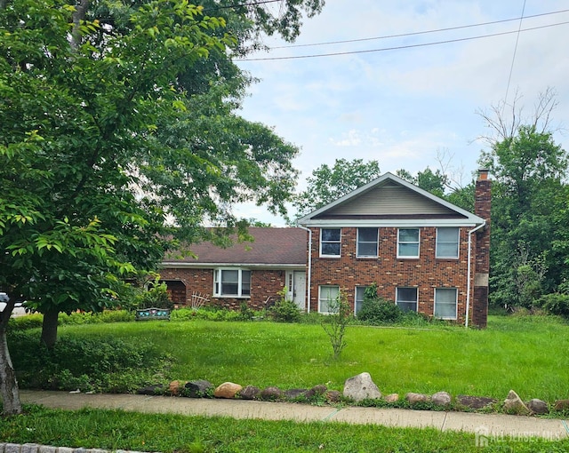 56 School St, Piscataway, NJ 08854 - view of front facade featuring a chimney, brick siding, and a front yard