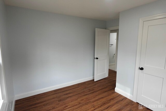 unfurnished bedroom with dark hardwood / wood-style flooring