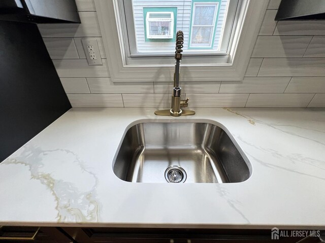 interior details with light stone countertops and sink