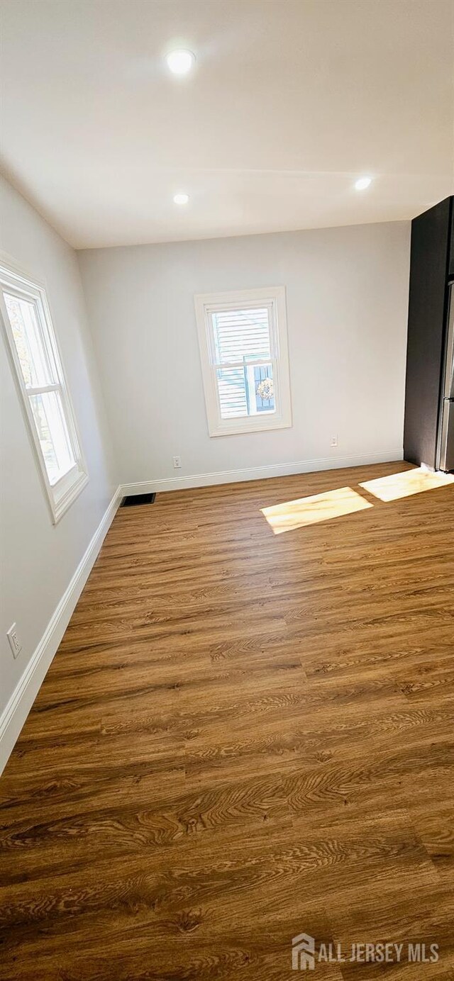 unfurnished room with dark hardwood / wood-style flooring