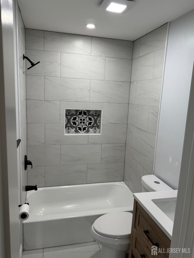 full bathroom with toilet, vanity, and tiled shower / bath combo