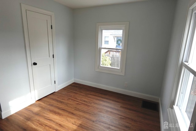 spare room featuring dark wood-type flooring