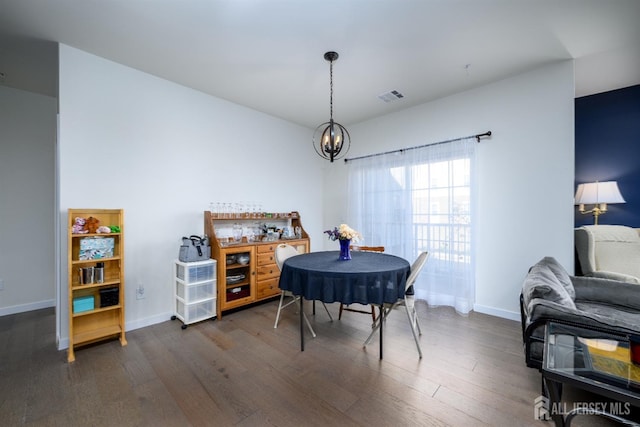 dining space with dark hardwood / wood-style flooring and a notable chandelier