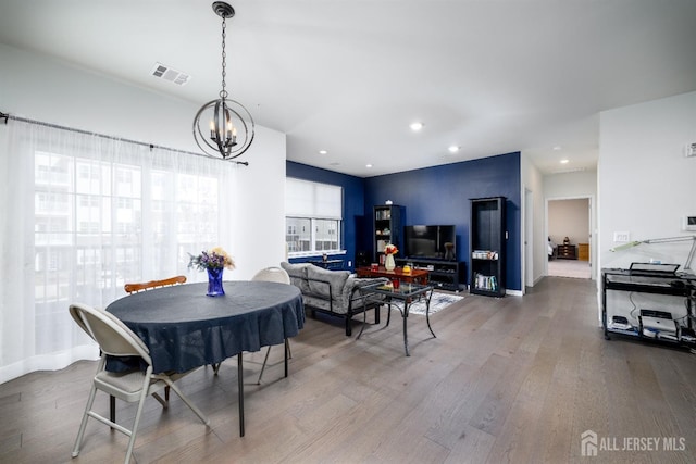 dining room with hardwood / wood-style flooring and a notable chandelier