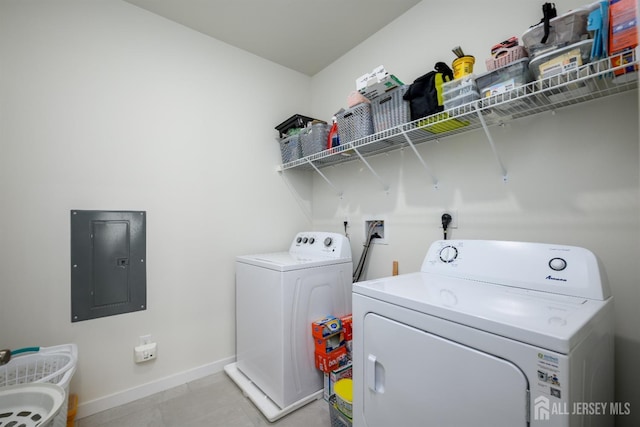 laundry room featuring light tile patterned flooring, washer and dryer, and electric panel