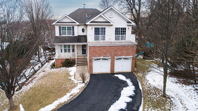 traditional home featuring driveway, a balcony, roof with shingles, a garage, and brick siding