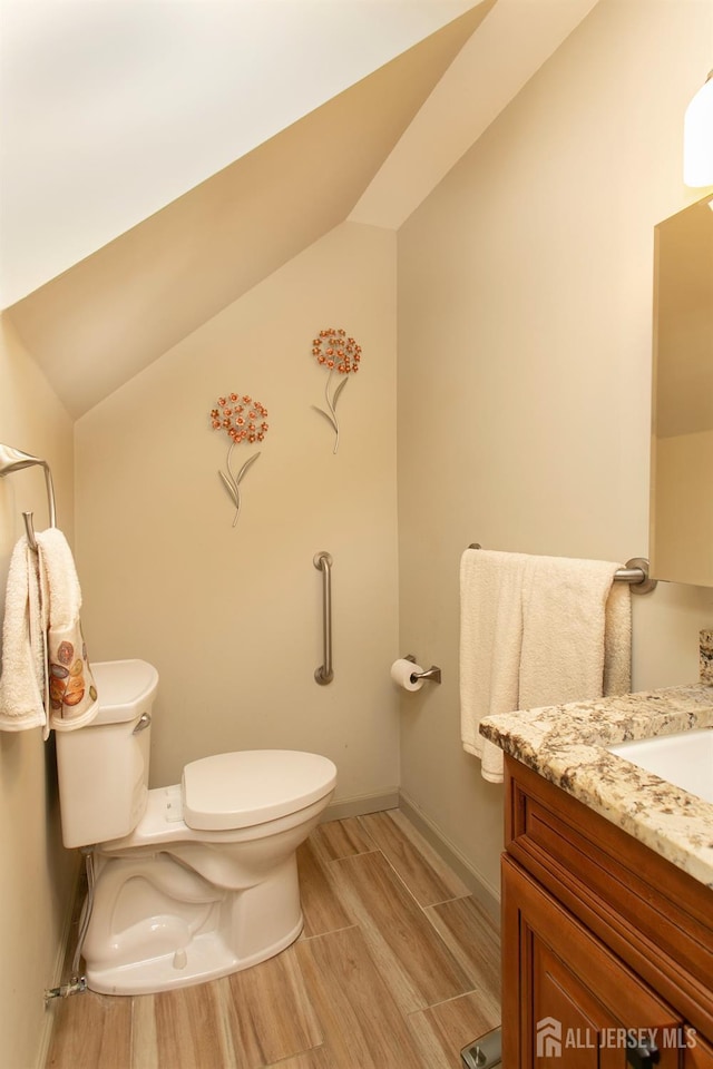 71 S Sagamore Ave, Edison, NJ 08820 - bathroom featuring toilet, vanity, wood finished floors, lofted ceiling, and baseboards