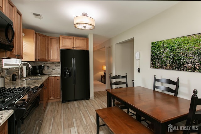 71 S Sagamore Ave, Edison, NJ 08820 - kitchen with black appliances, a sink, decorative backsplash, light stone countertops, and brown cabinetry