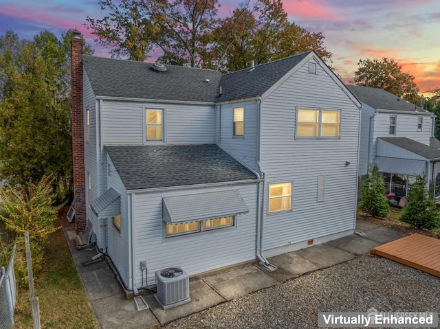 back house at dusk featuring central AC unit