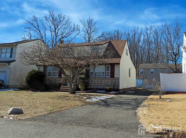 view of front of house featuring covered porch, driveway, and a shingled roof