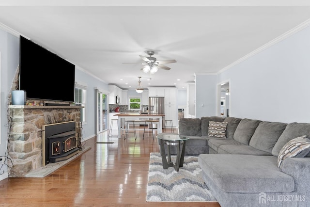 9 Hatakawana Ter, Mount Olive, NJ 07828 - living room featuring crown molding, a wood stove, light wood-type flooring, and ceiling fan