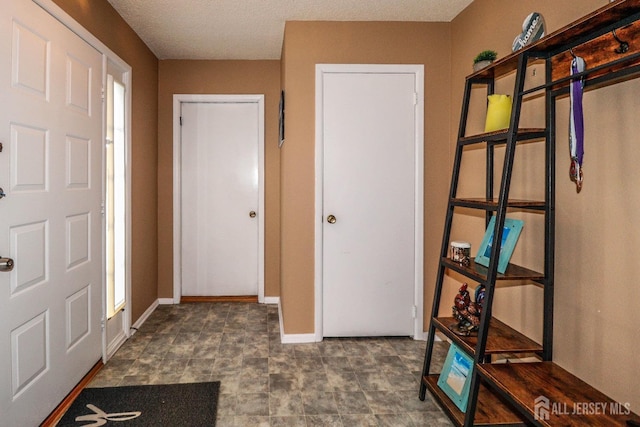 hallway with a textured ceiling and baseboards