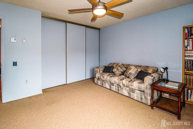 carpeted living area featuring ceiling fan
