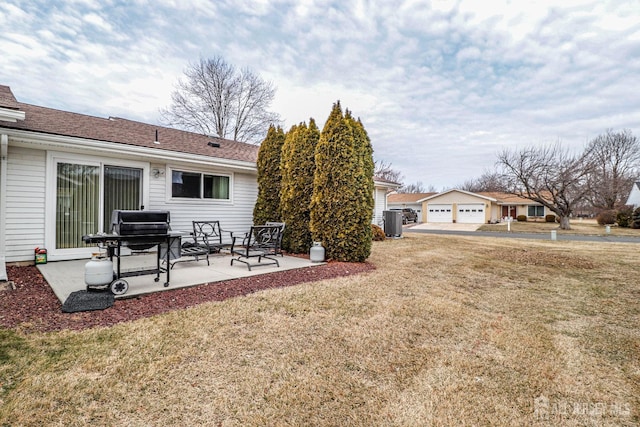 view of yard featuring central AC, a patio area, and a detached garage