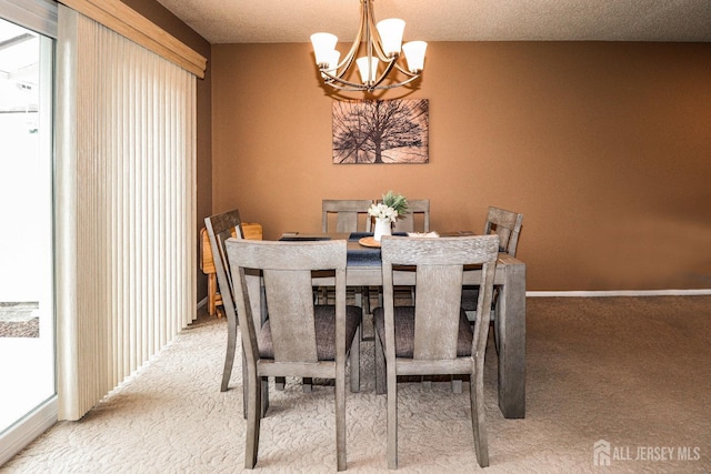 dining room with baseboards, a textured ceiling, carpet flooring, and an inviting chandelier