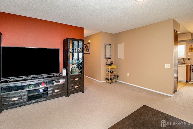 carpeted living area featuring a textured ceiling and baseboards