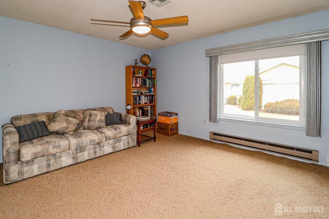 living room featuring visible vents, light colored carpet, baseboard heating, a ceiling fan, and a textured ceiling