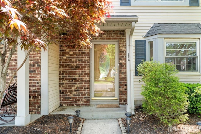 view of exterior entry featuring brick siding