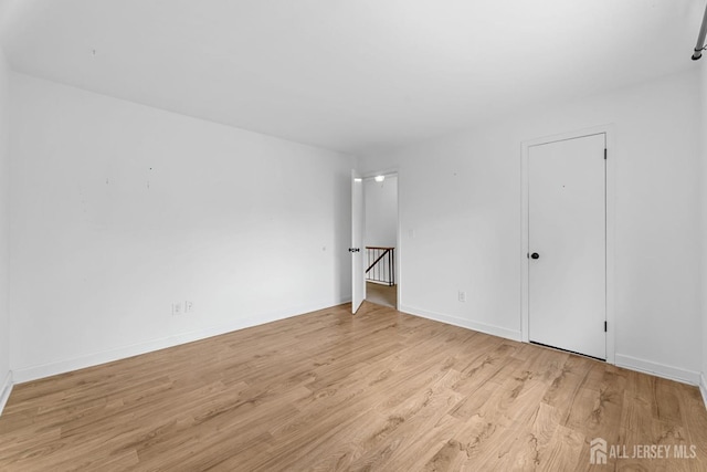 unfurnished room with light wood finished floors and baseboards