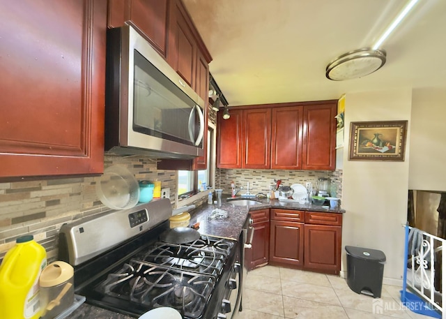 10 Van Buren Ave, Carteret, NJ 07008 - kitchen featuring appliances with stainless steel finishes, dark brown cabinets, backsplash, and dark stone counters