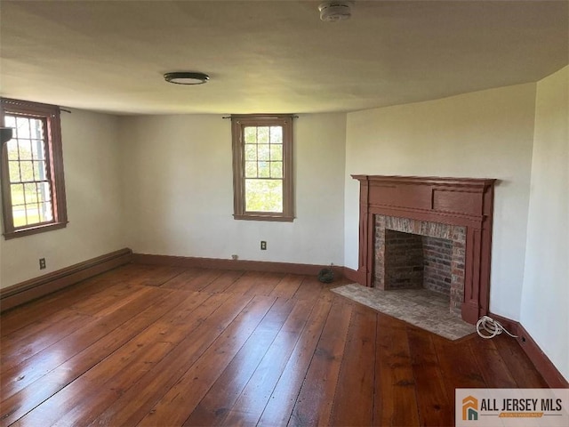 unfurnished living room featuring a fireplace, baseboards, and hardwood / wood-style floors