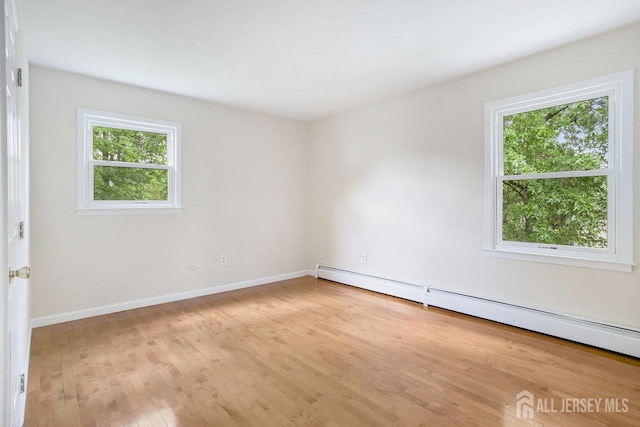 15 Meredith Rd, Edison, NJ 08817 - empty room with a baseboard heating unit, healthy amount of natural light, wood finished floors, and baseboards